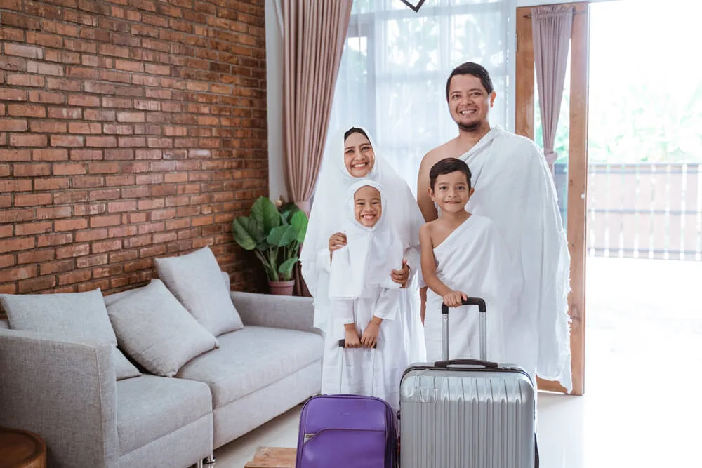 Muslim family wearing Ihram clothes with luggage preparing for Umrah pilgrimage from UAE