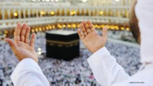 A Muslim pilgrim raising hands in prayer facing the Holy Kaaba in Masjid al-Haram, Makkah during Umrah.